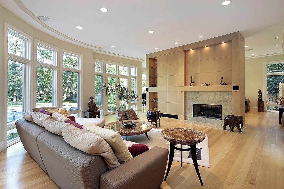 Modern living room created through a home addition in Raleigh, NC by Paradise Found Construction, featuring custom wood finishes and expansive windows.