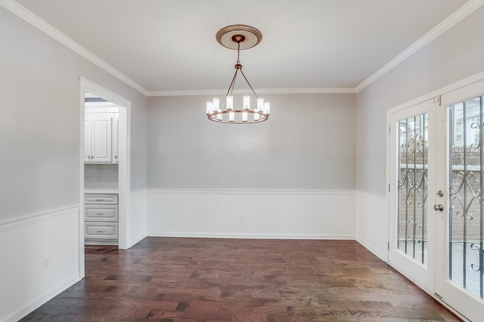 Elegant dining area created through a home addition in Wake Forest, NC by Paradise Found Construction, featuring hardwood floors and French doors.
