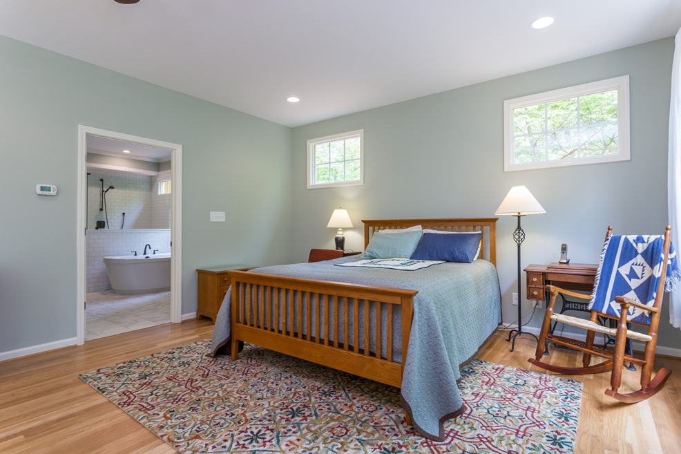 Accessible aging-in-place bedroom and bathroom suite with walk-in layout, hardwood floors, and freestanding tub—built by Jeff Wiblitzhouser of Paradise Found Construction, serving Raleigh, Cary, Apex, Wake Forest, and Holly Springs.